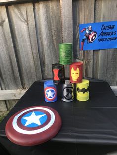 the table is set up with captain america's shieldman cups and napkins