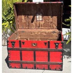 an old trunk is painted red and black