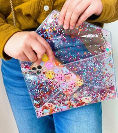 Carry confetti wherever you go thanks to this convertible envelope clutch. With a detachable chain to wear as a crossbody bag, this perfect clutch is the easiest day-to-date night accessory out there you (and all your friends too) are gonna need. It comes with 2 straps so you can wear it 4 ways - crossbody, clutch, wristlet or shoulder bag. Made from heavy-duty clear vinyl filled with colorful confetti and has gold hardware. Measures 10" x 6.5". Removable gold leatherette wristlet strap included Cheap Rectangular Clutch For Festivals, Cheap Portable Clutch Pouch, Luxury Multicolor Clutch As A Gift, Cheap Multicolor Formal Bags, Cheap Trendy Wristlet For Party, Cheap Embellished Clutch As Gift, Cheap Multicolor Clutch For Spring, Cheap Multicolor Clutch Evening Bag, Cheap Multicolor Clutch For Daily Use