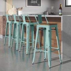 four white bar stools sitting in front of a counter