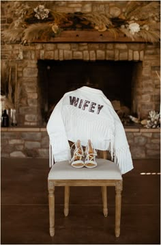 a pair of shoes sitting on top of a wooden bench in front of a fireplace