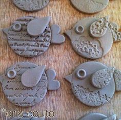 six clay birds sitting on top of a table next to each other with words written in them