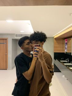 a man and woman taking a selfie in the bathroom with their cell phones together