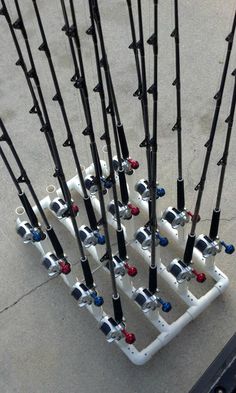 several fishing rods are attached to the side of a rack on the ground in front of a building