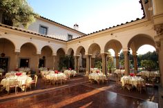 an outdoor dining area with tables and chairs set up for a formal function in the sun