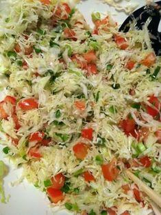 a salad with tomatoes, lettuce and shredded cheese on the top is ready to be eaten