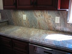 a granite counter top in a kitchen with wooden cabinets