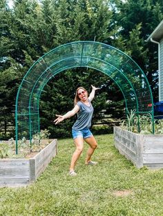 a woman standing in the grass with her arms outstretched