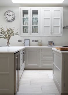 an image of a kitchen with white cabinets and grey flooring on the bottom right hand corner