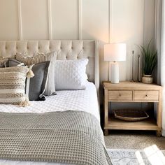 a bed with white sheets and pillows in a bedroom