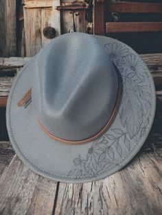 Add a touch of sophistication and style to your wardrobe with this stunning gray felt flat brim fedora hat. Handcrafted with care, this hat features a unique burned feather and floral motif, adding a touch of elegance to your look. The adjustable design ensures a comfortable fit for all head sizes, making it a versatile accessory for both men and women. The high-quality felt material provides durability and warmth, making it perfect for any season. Whether you're heading to a formal event or sim Gray Brimmed Fedora For Spring, Gray Short Brim Fedora For Spring, Flat Hats, Boho Hat, Grey Flats, Felt Fedora, Hat Ideas, Felt Material, Fedora Hat