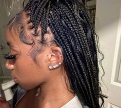 a woman with cornrows and piercings on her ear