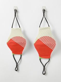 two bras hanging on the wall, one with an orange and white striped bra