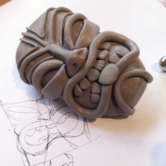 a sculpture made out of clay sitting on top of a table