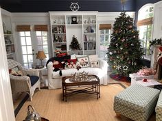 a living room filled with furniture and a christmas tree in the middle of the room