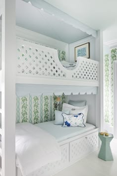 a white bunk bed sitting in a bedroom next to a green vase and window sill