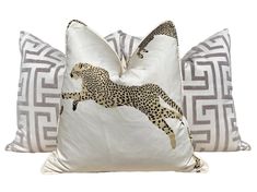 two pillows with cheetah and zebra designs on them, one in white and the other in grey