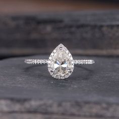 an engagement ring with a pear shaped diamond