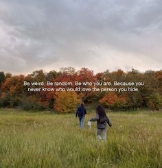 two people walking through a field with trees in the background and a quote written on it