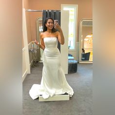 a woman in a white dress taking a selfie