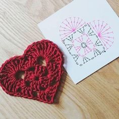 a crocheted heart sits next to a card with the word love written on it