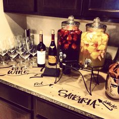 there are many bottles and glasses on the counter with some fruit in them to drink