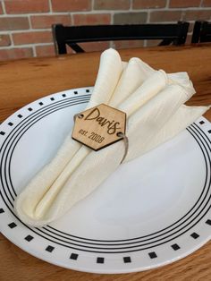 a white plate topped with two napkins on top of a wooden table