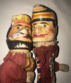 two wooden dolls are sitting next to each other