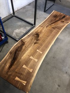 a piece of wood sitting on top of a floor next to a metal table with writing on it