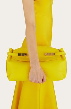 A wraparound belt secured with Gancio flip locks seems to embrace this spacious bag crafted of calfskin leather in a pouch-inspired silhouette. Carry it in hand or attach the adjustable strap for crossbody carry. Open top Removable, adjustable crossbody strap Interior zip pocket Leather Made in Italy Designer Handbags Evening Bags With Fold Over Clasp In Calf Leather, Luxury Yellow Calf Leather Bags, Chic Outfits Classy, Sophisticated Outfits, Dinner Outfits, Classy Chic, Open Top, Pouch Bag, Sophisticated Style