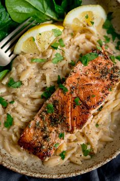 salmon and pasta with lemon wedges in a bowl