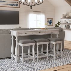 a dining room table with four chairs and a tv mounted on the wall above it