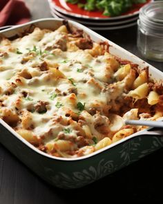 a casserole dish with meat, cheese and sauce in it on a table