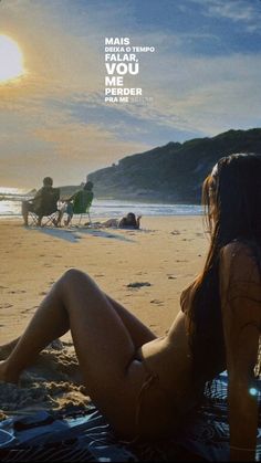 a woman sitting on top of a sandy beach