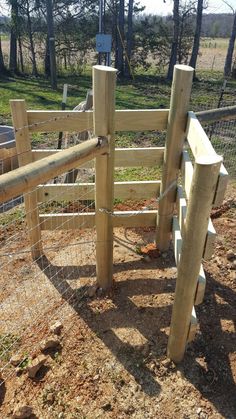 the fence is made out of wood and has two posts on each side, along with an iron bar