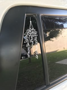 a car window decorated with white flowers and leaves