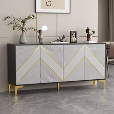 a white and yellow sideboard sitting in a living room next to a plant on top of a table