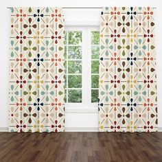 the curtains in this room are decorated with colorful geometric shapes and circles, while the floor is