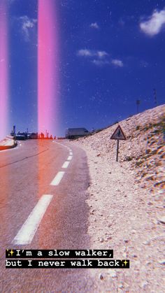 two pink beams are seen in the sky above a road with cars on it and a sign that says, i'm a slow walker but i never walk back