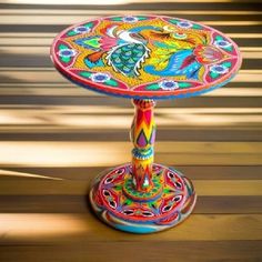 a colorful table sitting on top of a wooden floor