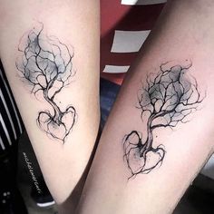 two people with tattoos on their legs, one has a tree and the other has a heart