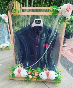 a mannequin in a box with flowers around it