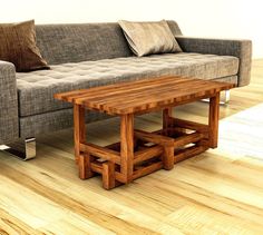 a wooden table sitting next to a couch on top of a hard wood floor