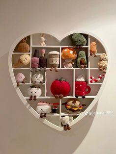 a heart shaped shelf filled with lots of different stuffed animals and toys on it's sides