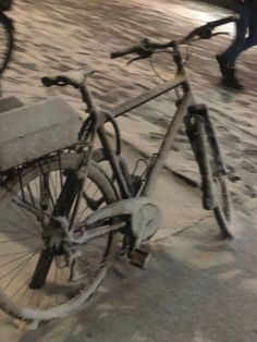 a dirty bike parked on the side of a street