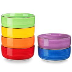 four colorful bowls stacked on top of each other in different colors and sizes, with one empty bowl next to it