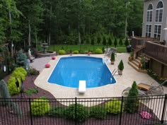 an above ground swimming pool surrounded by landscaping