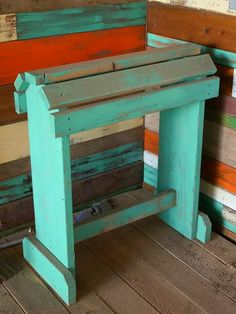 a bench made out of old wooden planks and painted in different shades of blue