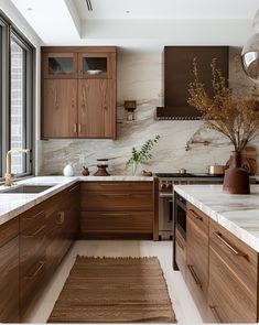 a kitchen with marble counter tops and wooden cabinets, along with an area rug on the floor