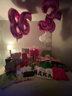 the bed is covered with pink balloons and other items for someone's 30th birthday